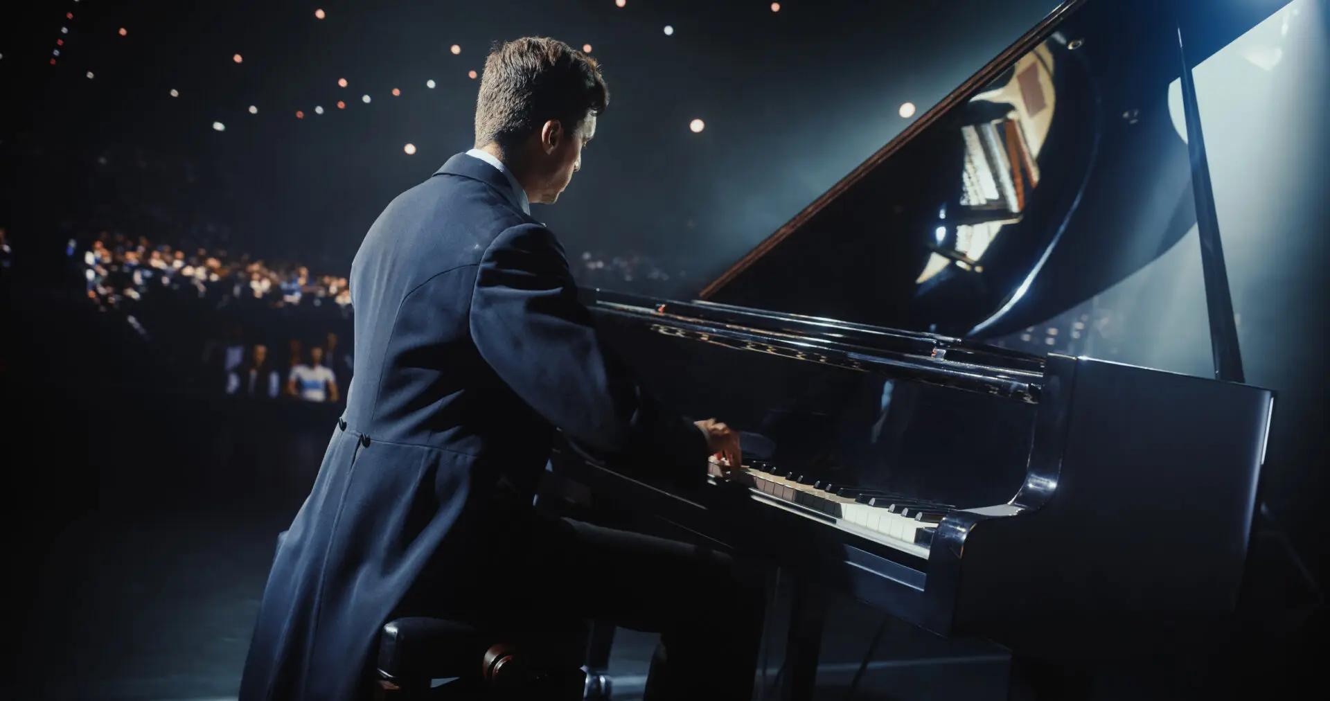 Pianist performing on stage with grand piano.